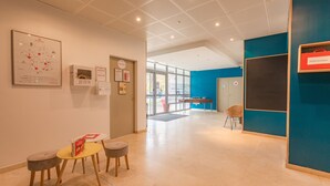 Un interior moderno con una mesa de recepción, un mapa en la pared y una pared azul de acento.