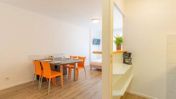 A modern kitchen with a wooden countertop, a coffee machine, and a potted plant.