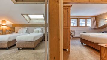 A bedroom with two beds, a skylight, and a view of the outside.