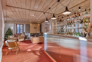 A bar area with wooden ceiling and shelves of liquor bottles.