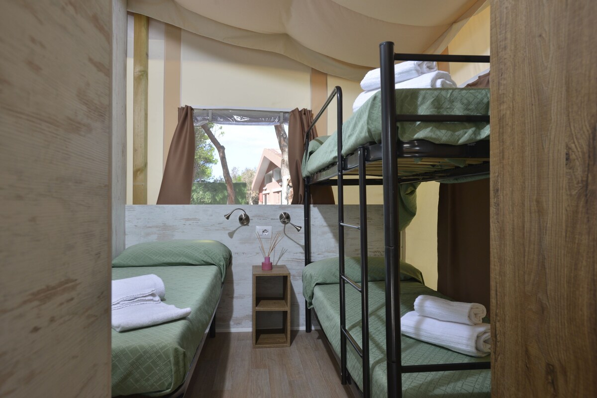 A bunk bed room with two single beds and a small table with a lamp.