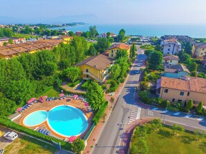 Un barrio residencial con piscina, una señal de parada y vista al mar.