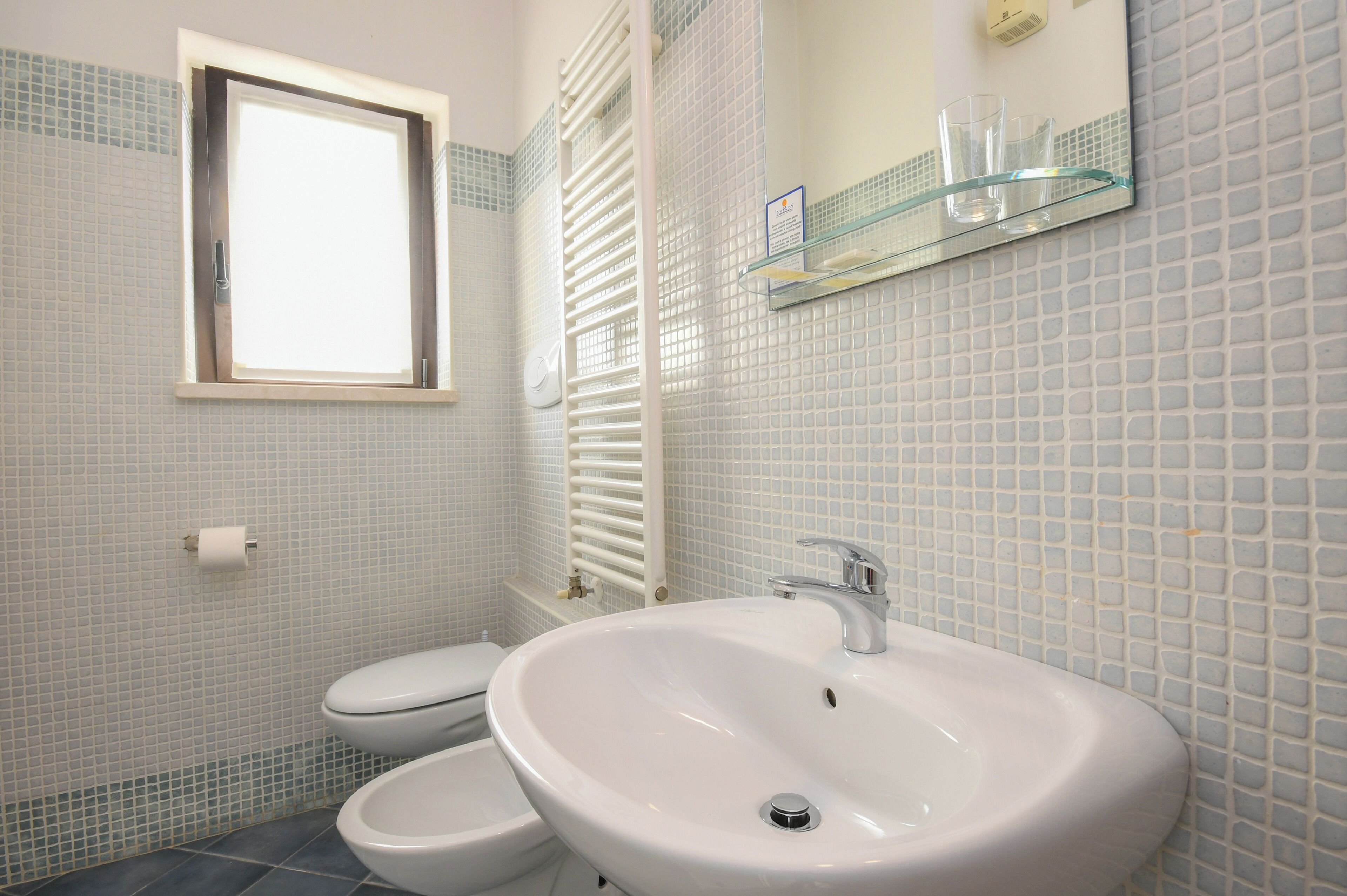 A bathroom with a toilet, bidet, and sink.