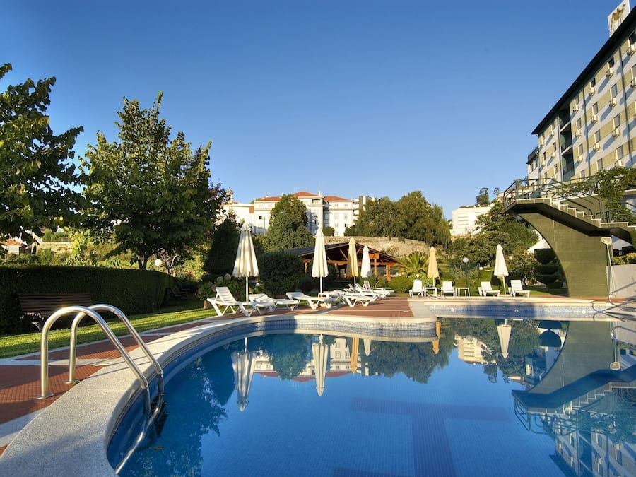 Una piscina al aire libre de temporada, sillones reclinables de piscina