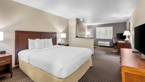 A hotel room with a large bed, a desk, a chair, a TV, and a window with blinds. - Comfort Inn & Suites Thatcher - Safford (Thatcher)