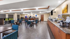 A spacious hotel lobby with multiple seating areas, a buffet counter, and a television mounted on the wall. - Comfort Inn & Suites Thatcher - Safford (Thatcher)