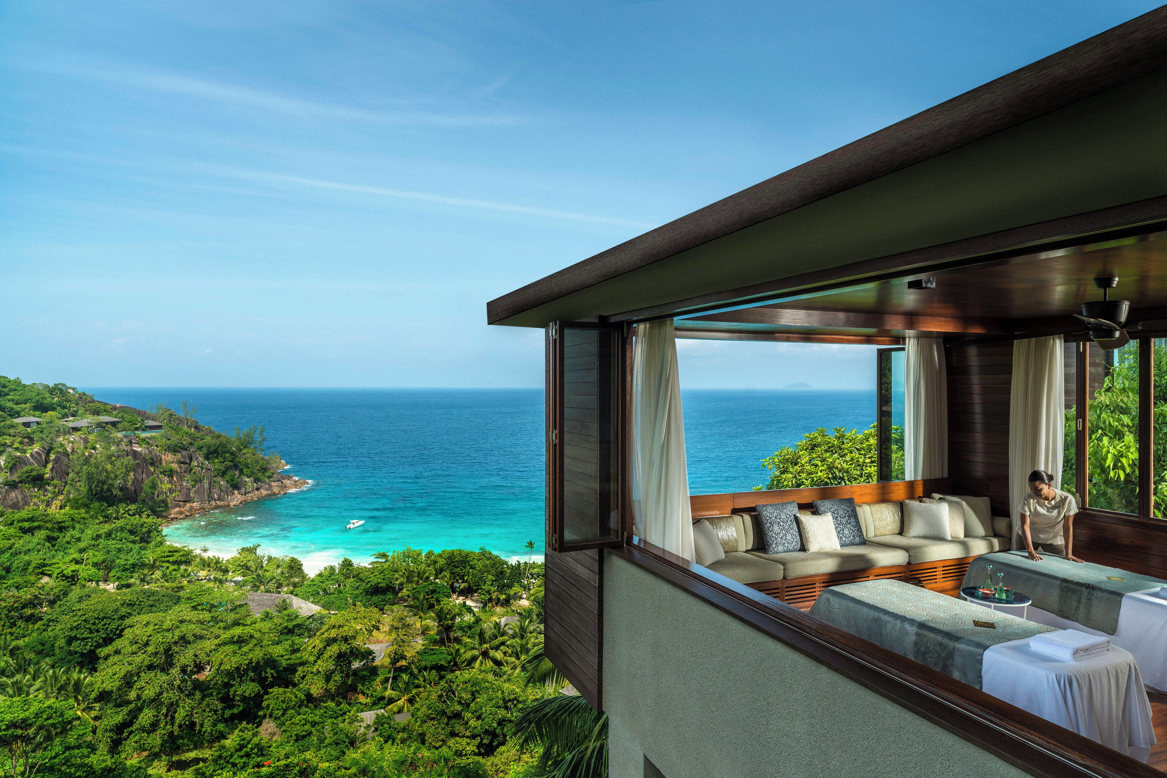 Ein Balkon mit Blick auf das Meer und eine Person, die am Fenster steht.
