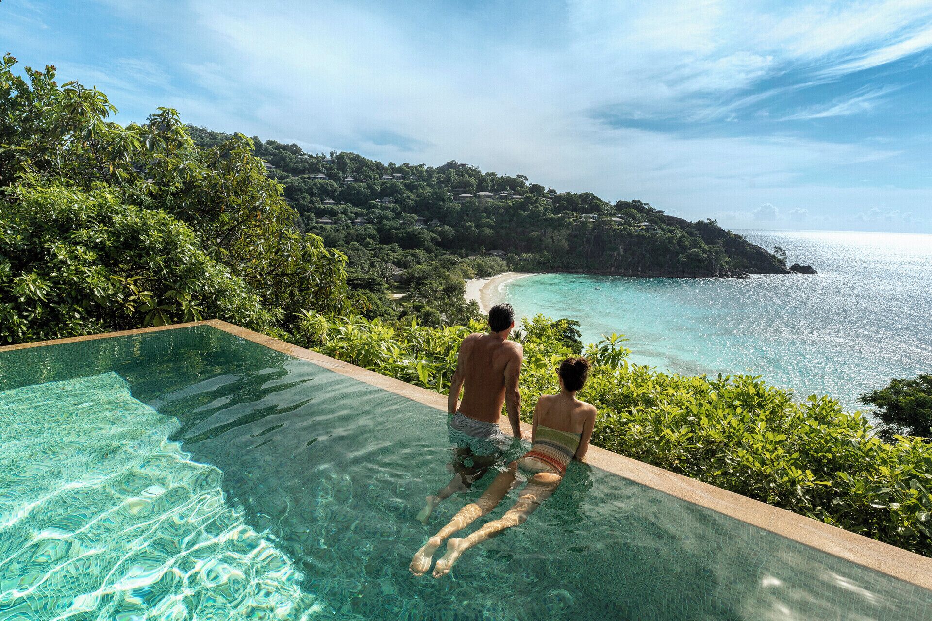 Ein Pool ohne Ende mit Blick auf Strand und Wald.