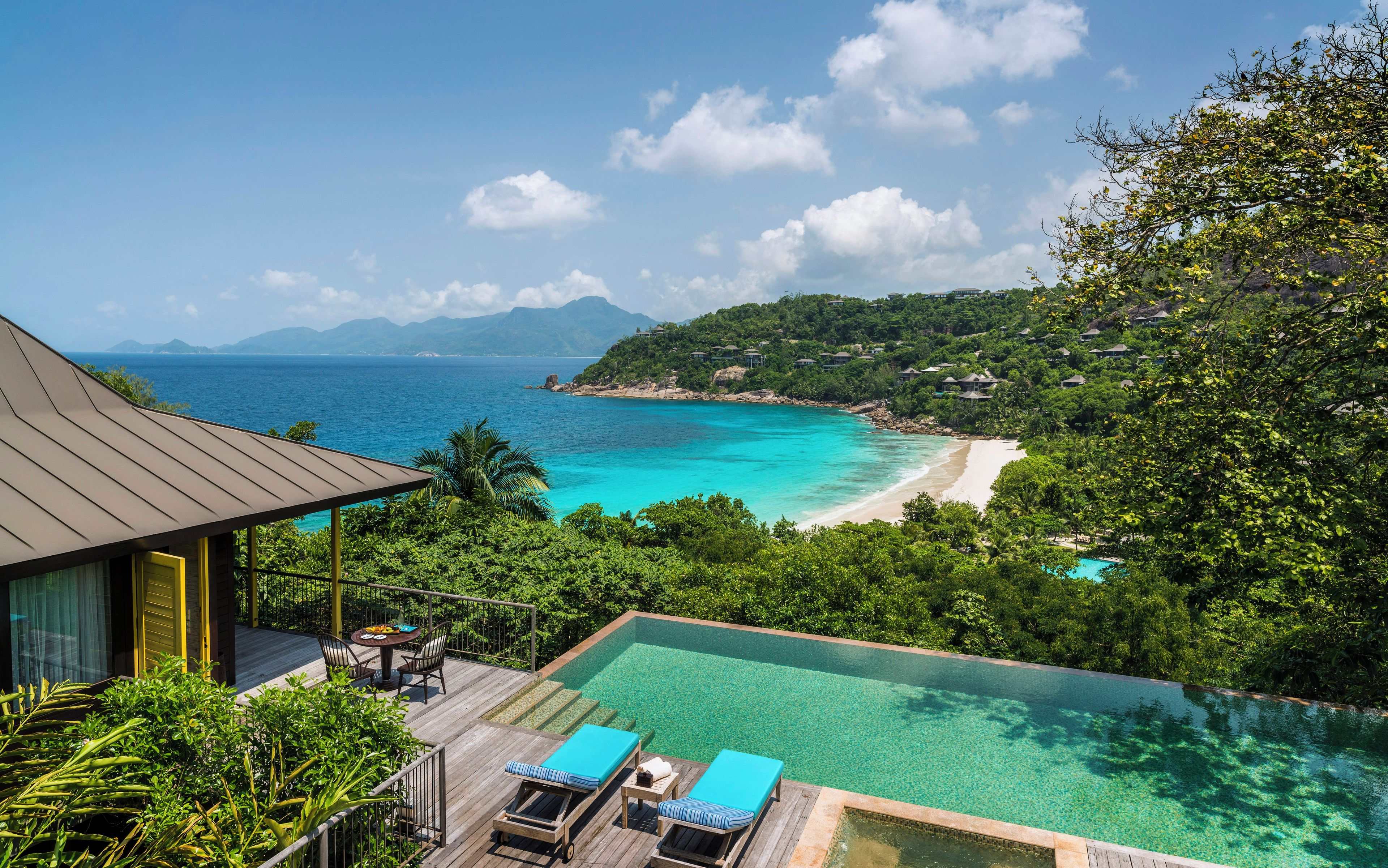 A resort with an infinity pool overlooking a beach and ocean.