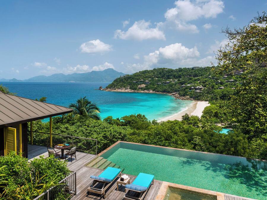 Un resort con piscina infinita con vistas a una playa y al océano.