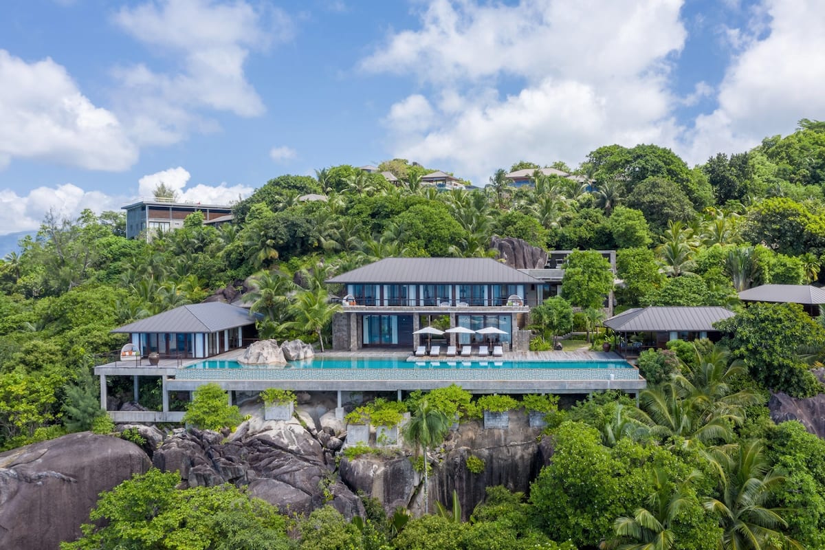 Ein modernes Resort mit Pool, mehreren Gästezimmern und üppiger tropischer Landschaft.