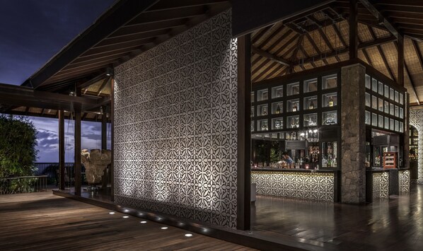 An outdoor bar area with a patterned wall and wooden flooring. - Four Seasons Resort Seychelles (Mahé Island)