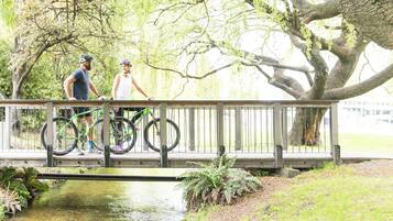 Un puente de madera sobre un cuerpo de agua pequeño, con dos bicicletas estacionadas.