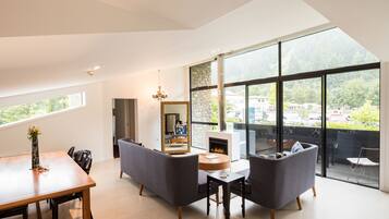 A spacious living room with a large window, a fireplace, and a dining area.