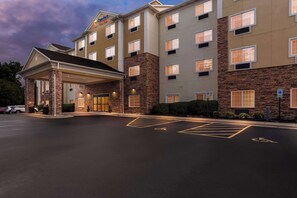 Hotel features a covered entrance and designated parking spaces.