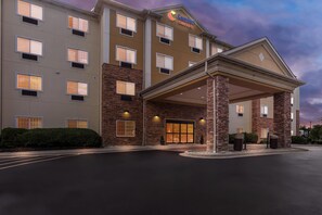 A hotel with a covered entrance, multiple windows, and a sign indicating it's a Comfort Suites hotel. - Comfort Suites Grayslake near Libertyville North (Grayslake)