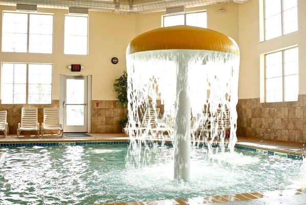 Una piscina techada, sillones reclinables de piscina