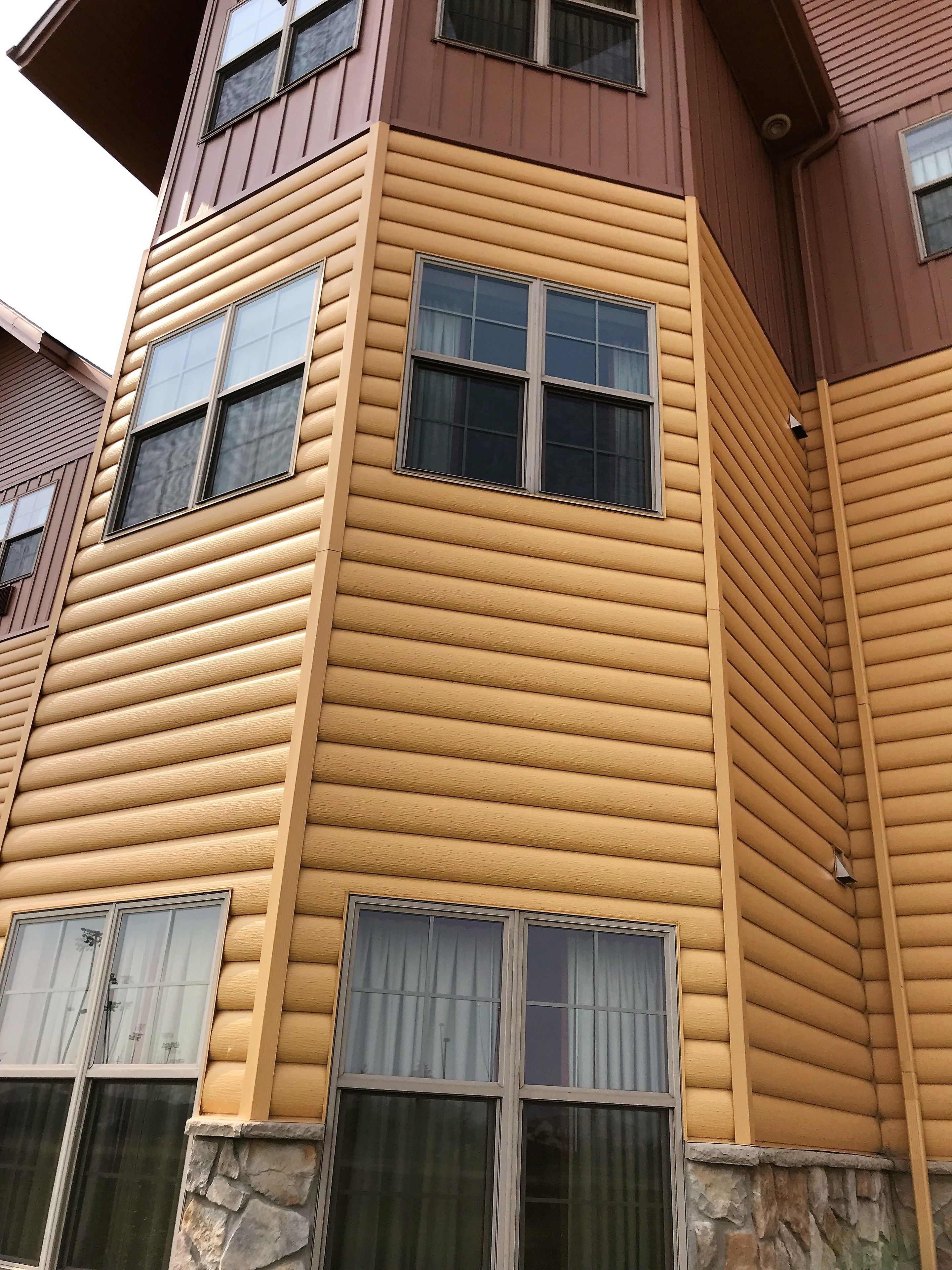 Un immeuble à plusieurs étages, doté d’un revêtement horizontal et de fondations en pierre.