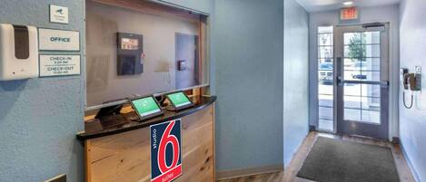 A reception desk with a sign indicating '6 suites' and a check-in/out schedule.
