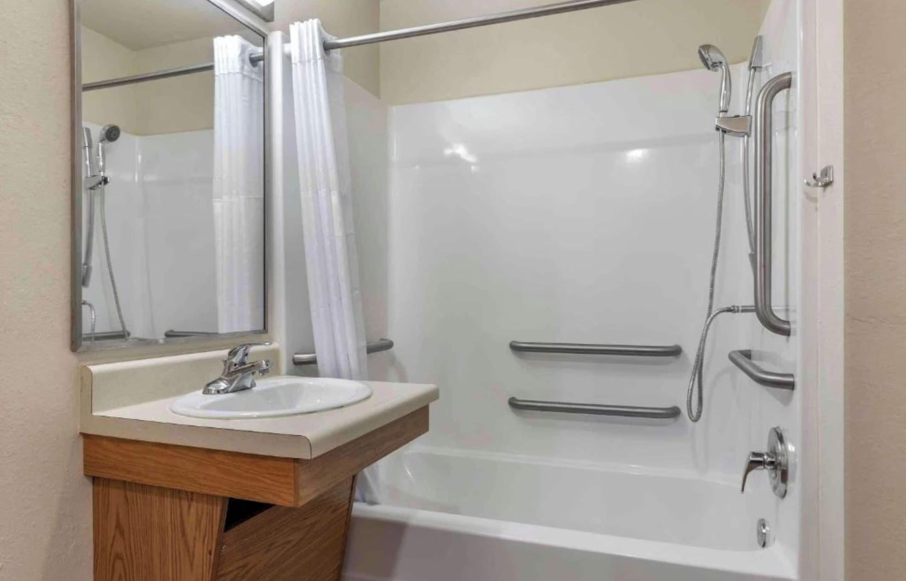 Une salle de bain avec un lavabo blanc, un miroir et une douche.