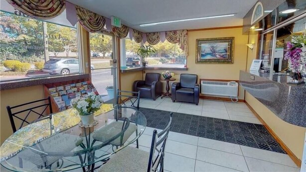 A hotel lobby with a reception desk, seating area, and a view of the street outside. - Econo Lodge Clemson - University Area (Clemson)
