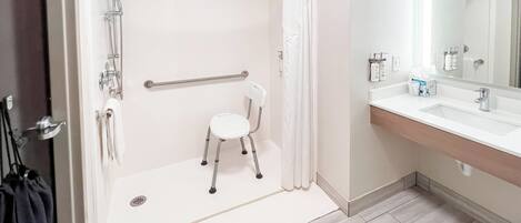 A modern bathroom with a shower, toilet, and sink.