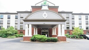 A Holiday Inn Express & Suites building with a brick facade, white columns, and a large entrance. - Holiday Inn Express Hotel & Suites Kodak East - Sevierville by IHG (Kodak)