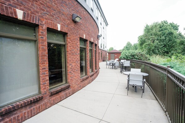 A brick building with large windows and outdoor seating. - Holiday Inn Express Hotel & Suites Kodak East - Sevierville by IHG (Kodak)