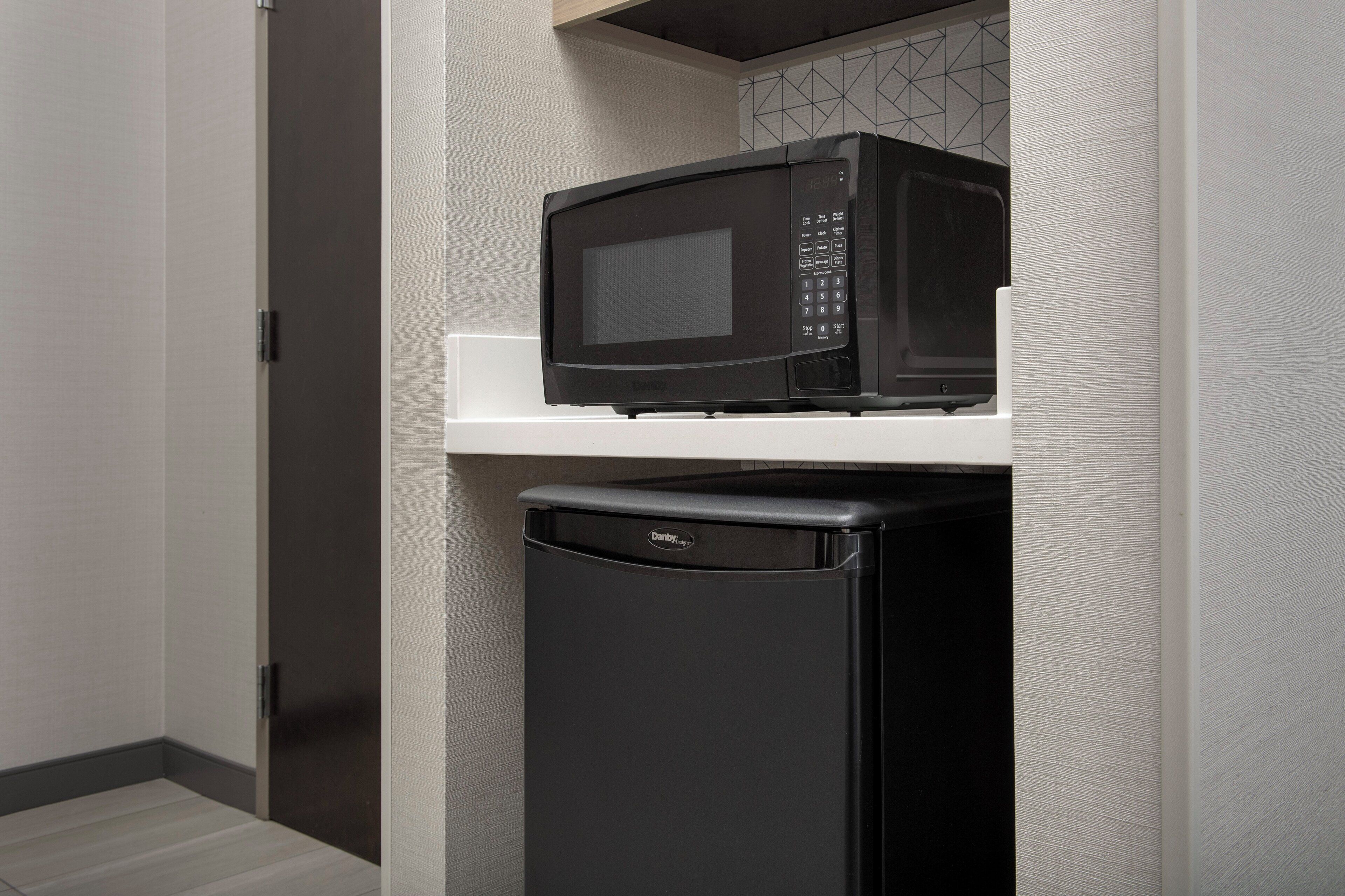 A compact kitchen area with a microwave and a refrigerator.