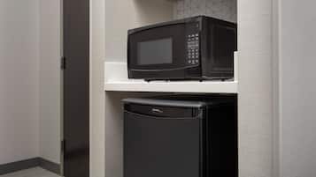 A compact kitchen area with a microwave and a refrigerator.