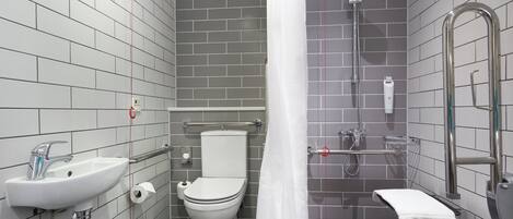 Un baño moderno con inodoro, lavamanos, ducha y toallero.