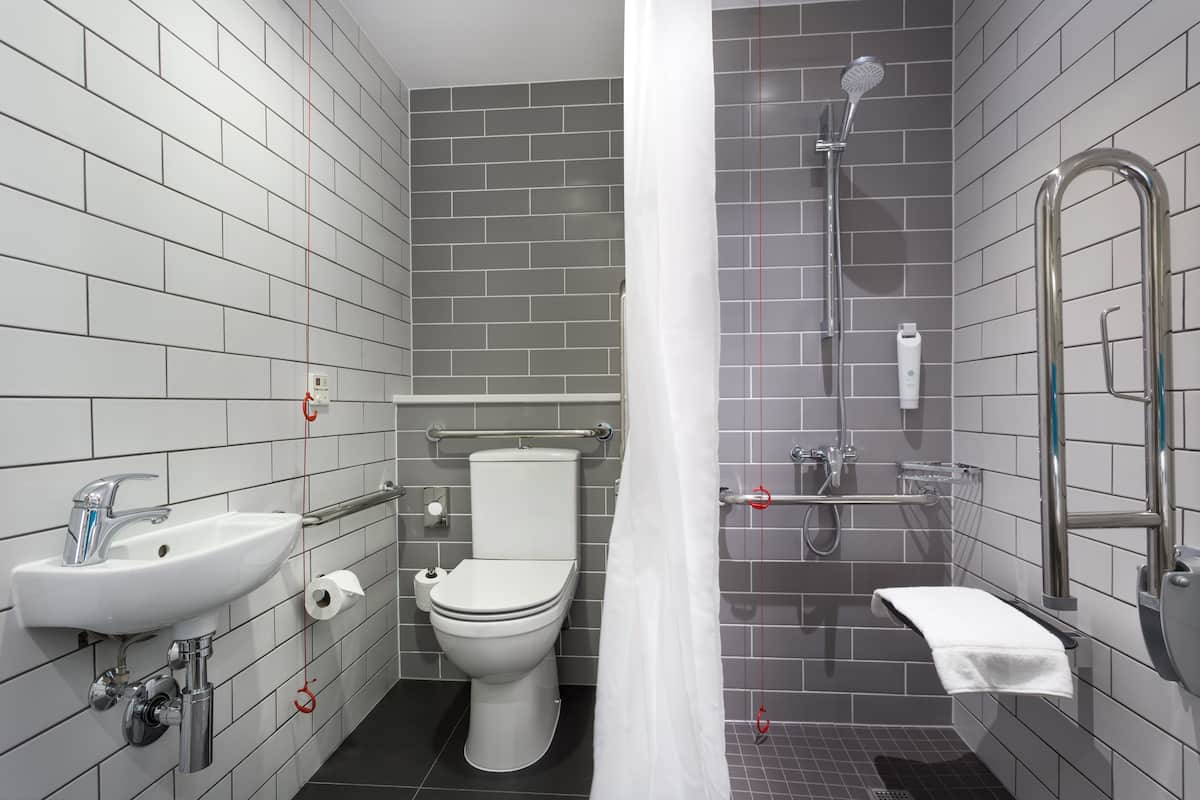 A modern bathroom with a white sink, toilet, and shower.