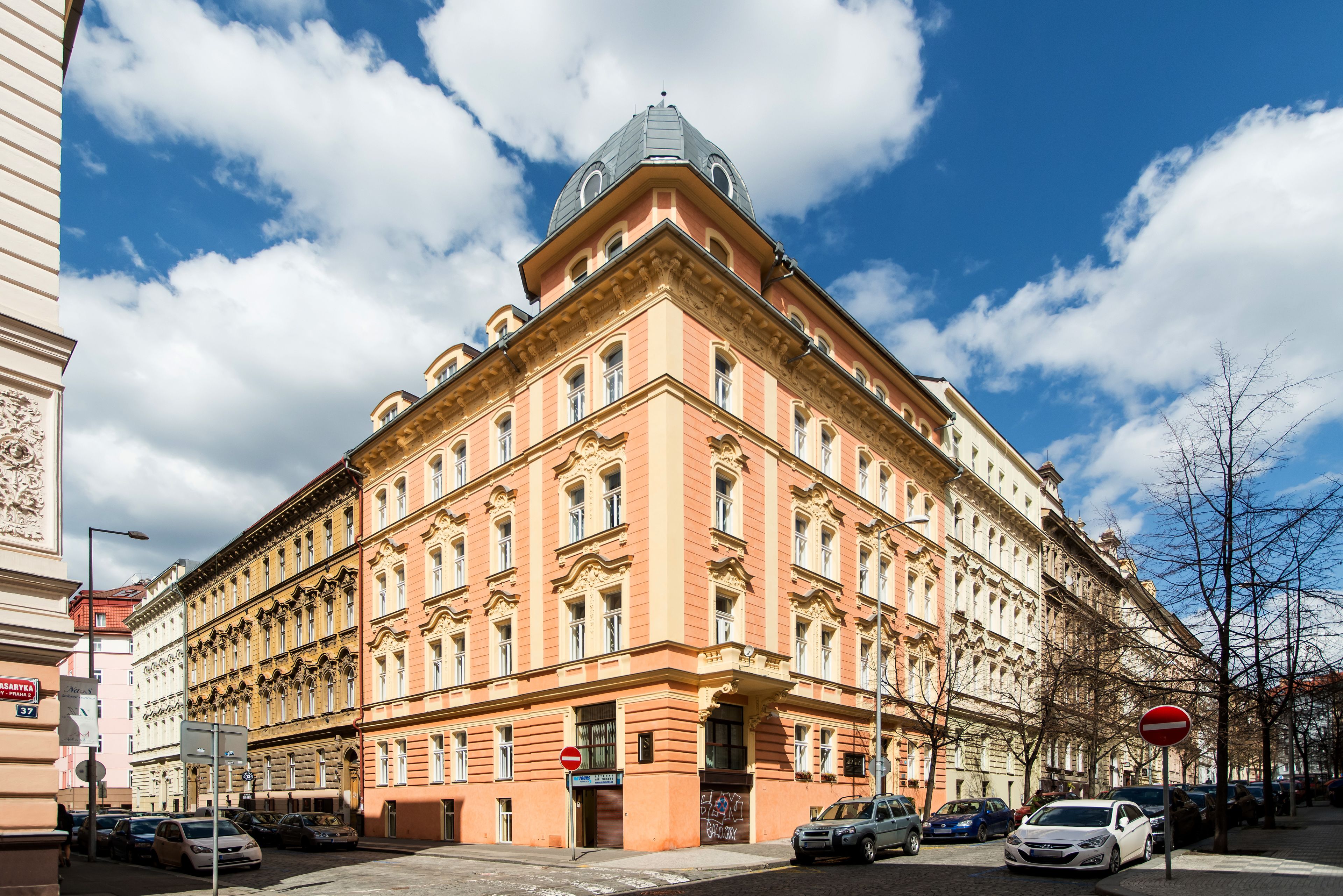 A large, historic building with classical architecture, multiple windows, and a prominent dome.