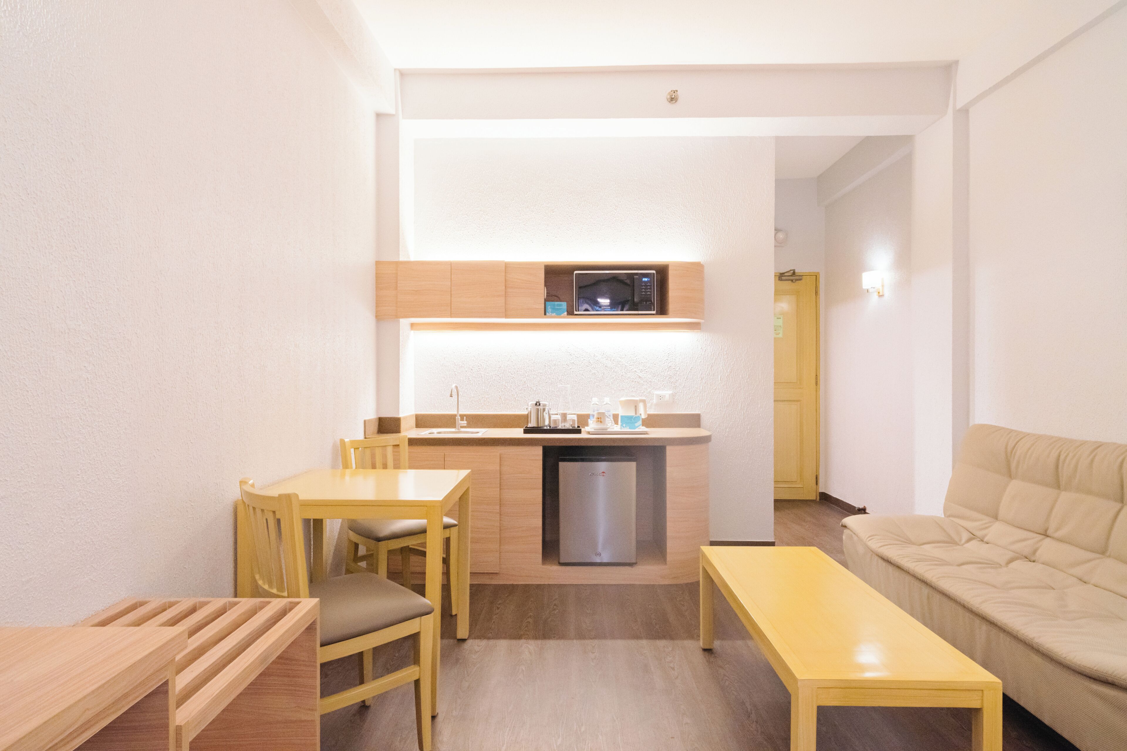 A compact living space with a kitchenette, a dining area, and a seating area.