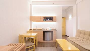 A compact living space with a kitchenette, a dining area, and a seating area.