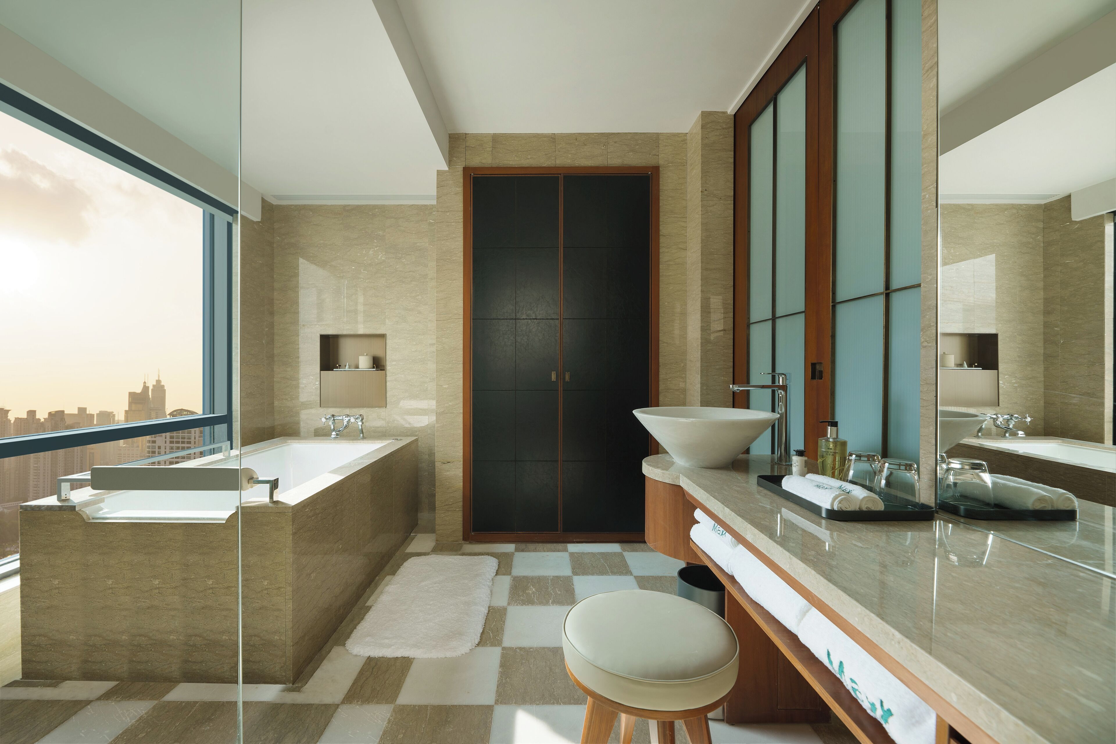 Une salle de bain moderne avec une grande baignoire, un meuble-lavabo à deux vasques et un grand miroir.