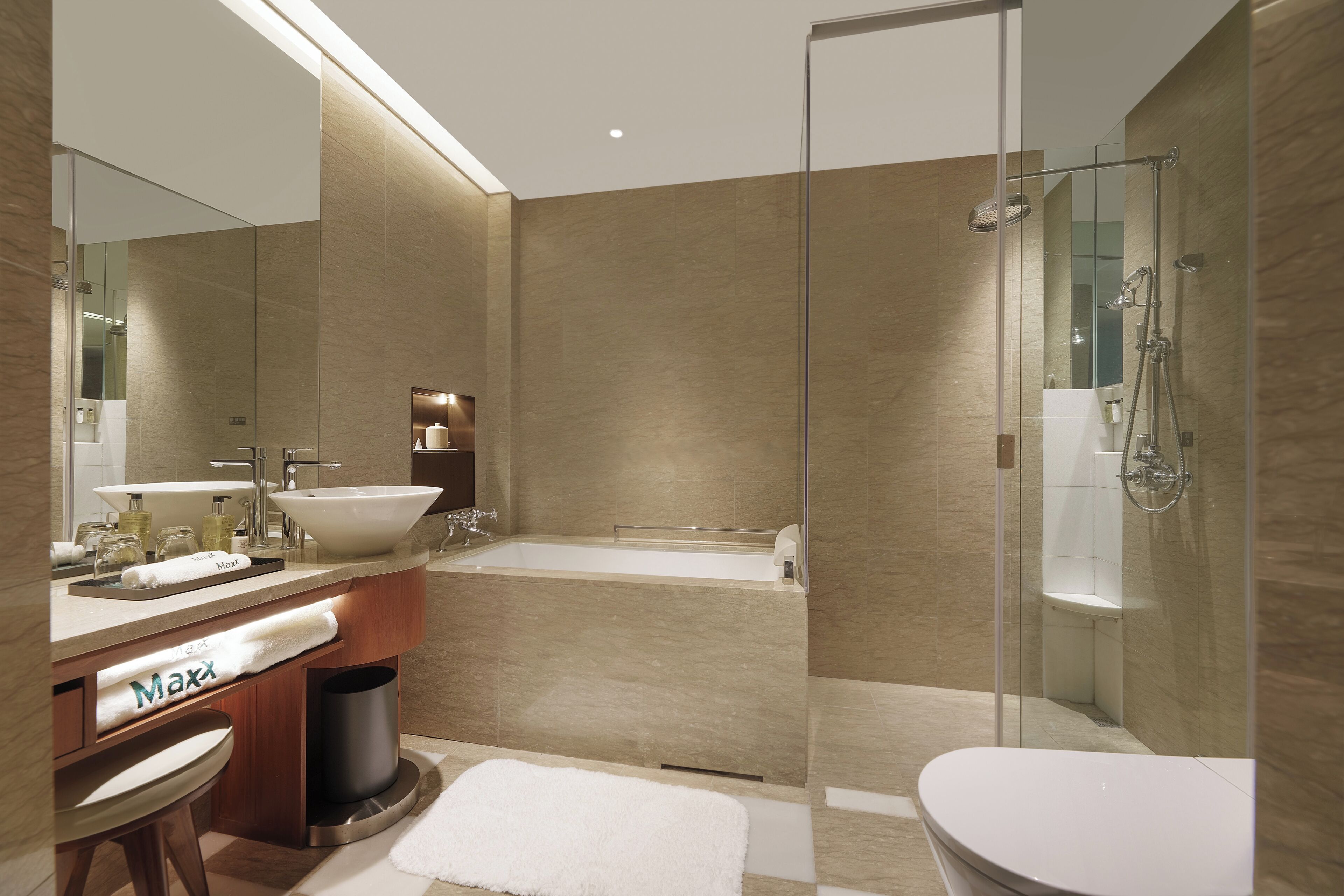A modern bathroom with a large sink, bathtub, and glass-enclosed shower.