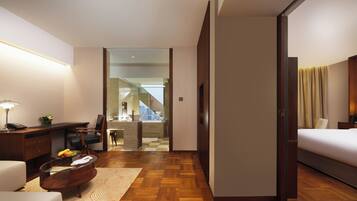 Habitación de hotel con cama, escritorio, silla y vista a una escalera que conduce a un balcón.