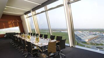 A conference room with a large table, chairs, and a view of an airport.