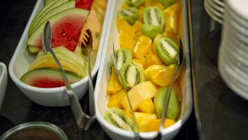 A buffet with various fruits including watermelon, kiwi, and mango.