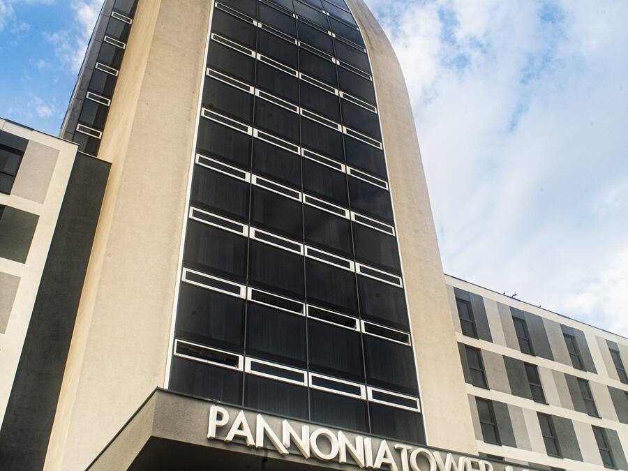 L’hôtel Pannon Tower se distingue par son architecture moderne, caractérisée par une structure verticale imposante et un grand auvent d’entrée.