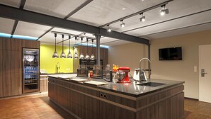 Una cocina moderna con una isla central, armarios de madera y un refrigerador de vino empotrado.
