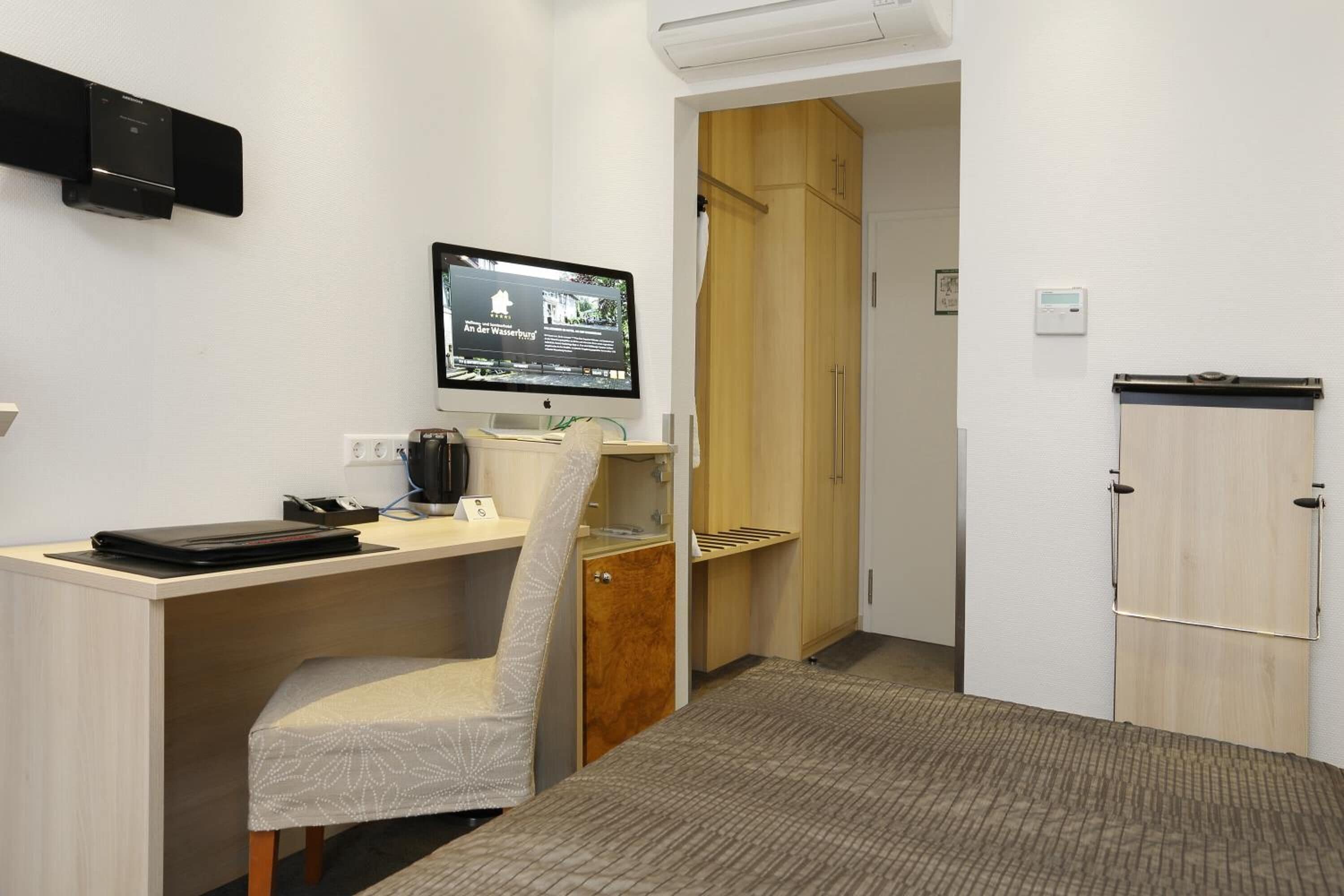 Une chambre d’hôtel équipée d’un bureau, d’une chaise et d’un téléviseur affichant une page web.
