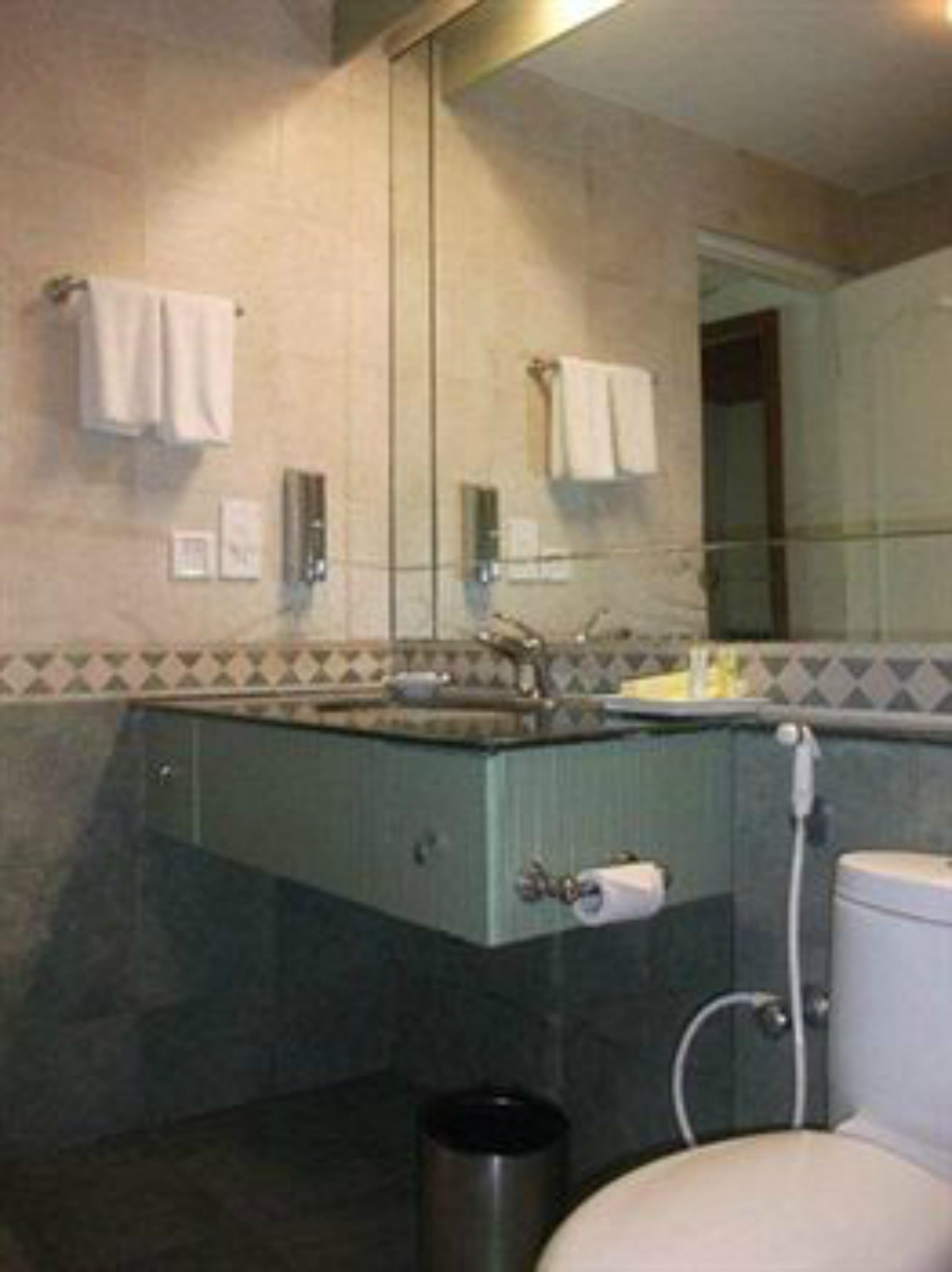 A bathroom with a sink, mirror, and toilet.