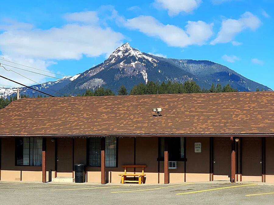 A building with a brown roof and a bench in front.