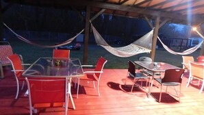 An outdoor patio with a glass table and metal chairs, a hammock, and a barbecue grill. - Packwood Inn (Packwood)