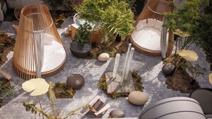 A rooftop garden with seating areas, a water feature, and various plants. - Grand Hôtel de Courtoisville (Saint-Malo)