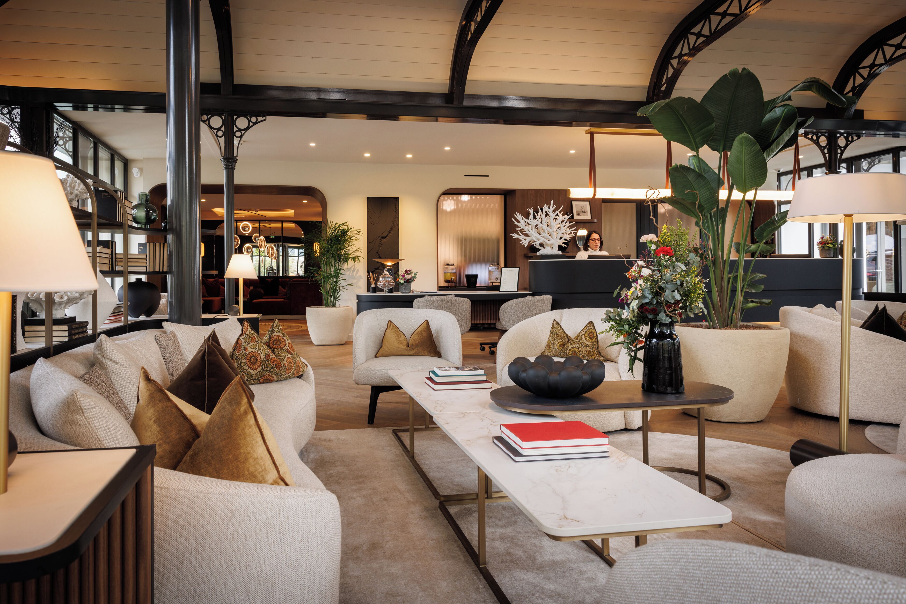 A spacious living area with a sofa, armchairs, a coffee table, and a reception desk.