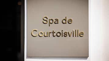 Un cartel con el texto 'Spa de Courtoisville' fijado a una pared.