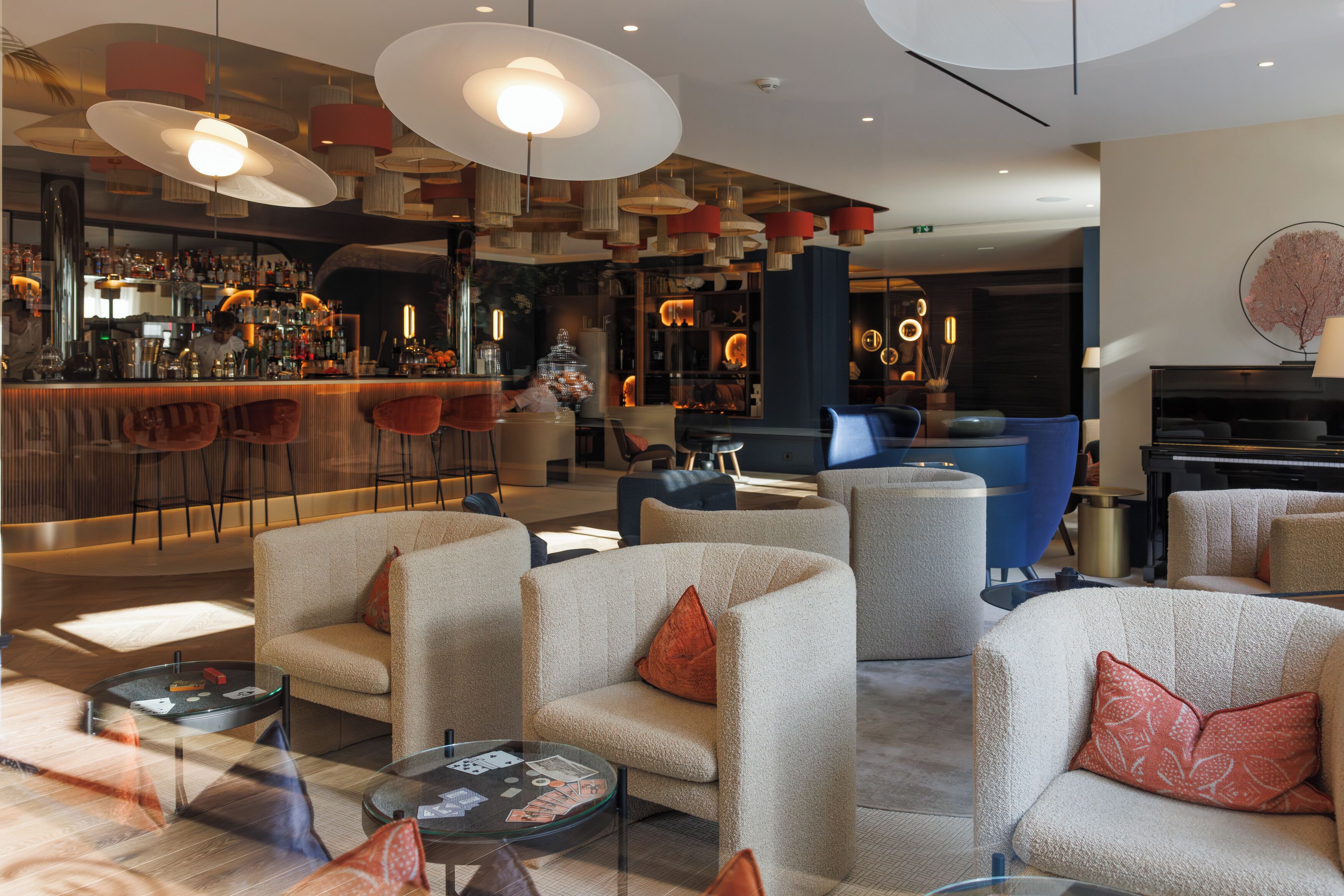 A modern lounge area with sofas, a bar, and ambient lighting.